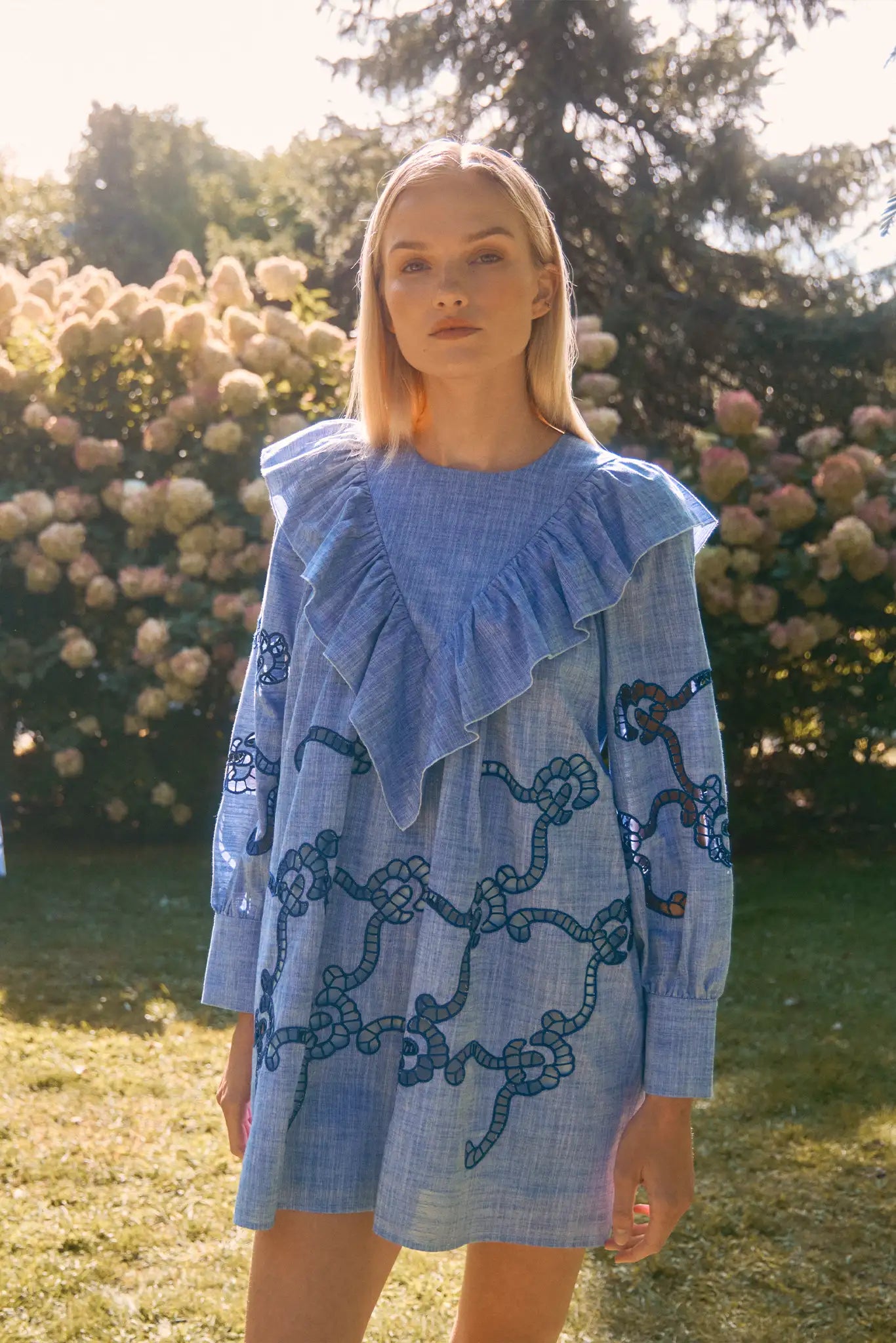 Blue cut-out embroidered linen, crew neckline, softly ruffled yoke, long sleeves with button cuffs