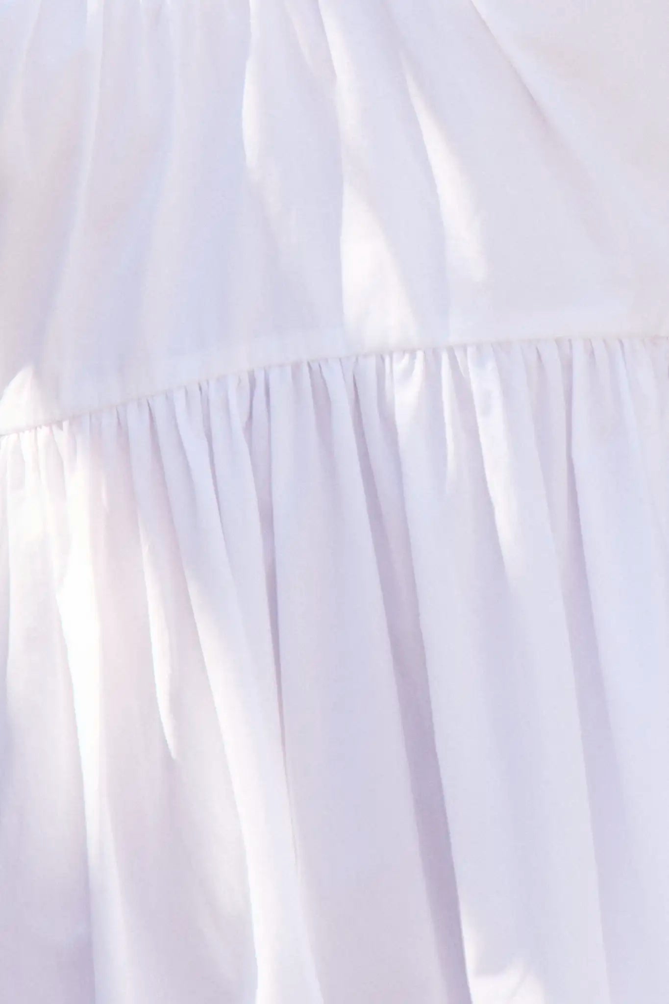 Close up of the Augusta Dress, white cotton dress with ruched V neckline.