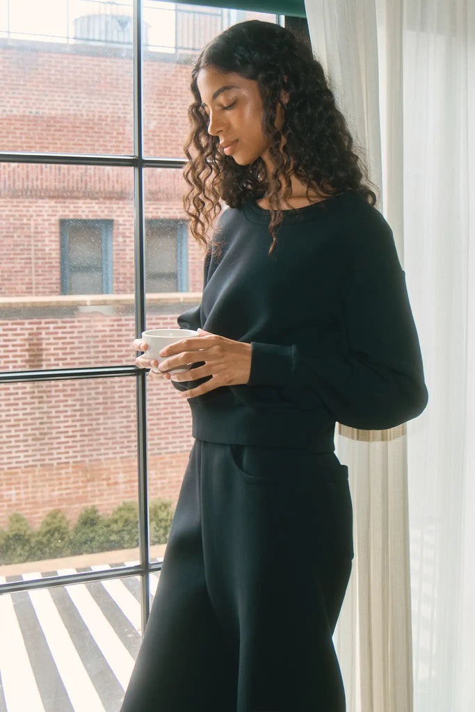The Jennie Sweatshirt is a structured scuba in deep Onyx with pleated long sleeves.