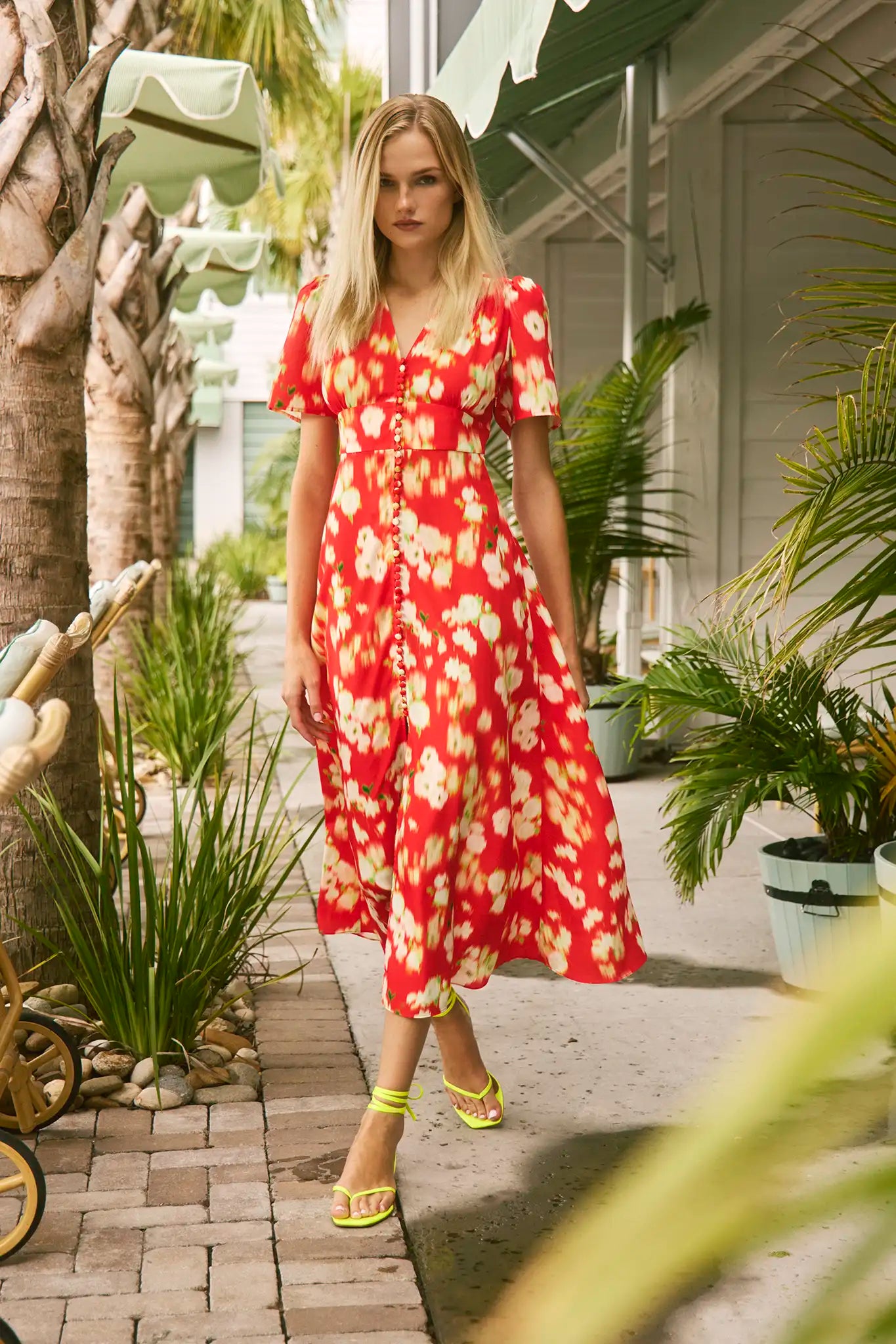 An A-line fitted waist midi dress in an orange and yellow print