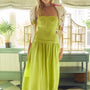 A strapless drop waist dress in a chartreuse linen with a full skirt.