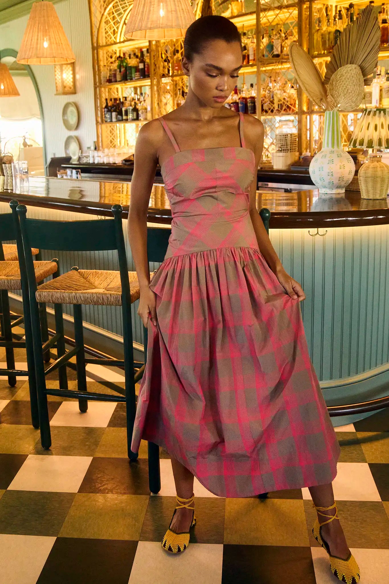 A pink and brown yarn-dyed plaid with slim spaghetti straps, subtle drop waist, and shirred skirt.