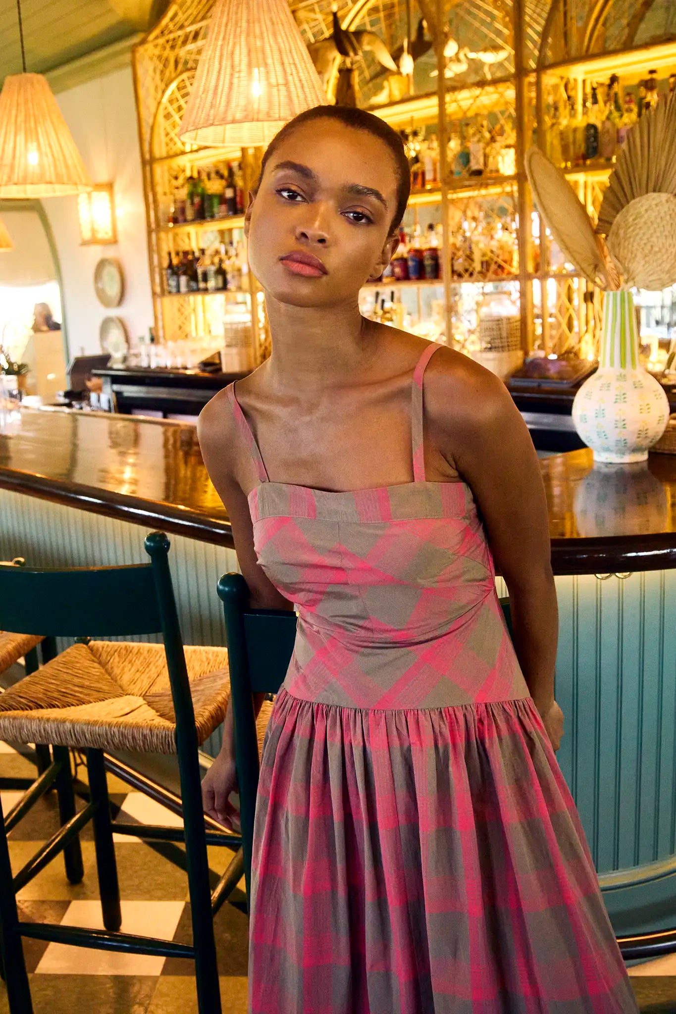 A pink and brown yarn-dyed plaid with slim spaghetti straps, subtle drop waist, and shirred skirt.