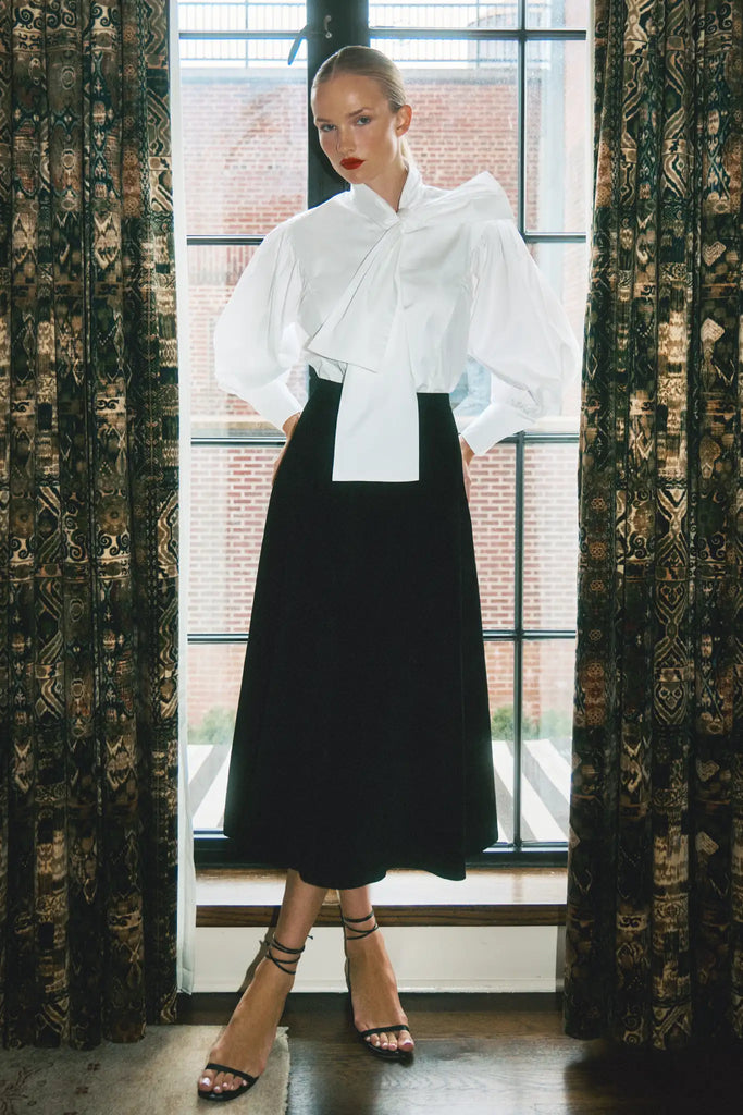 The Shay Blouse is designed with a tie-front neckline and long sleeves with angled button cuffs