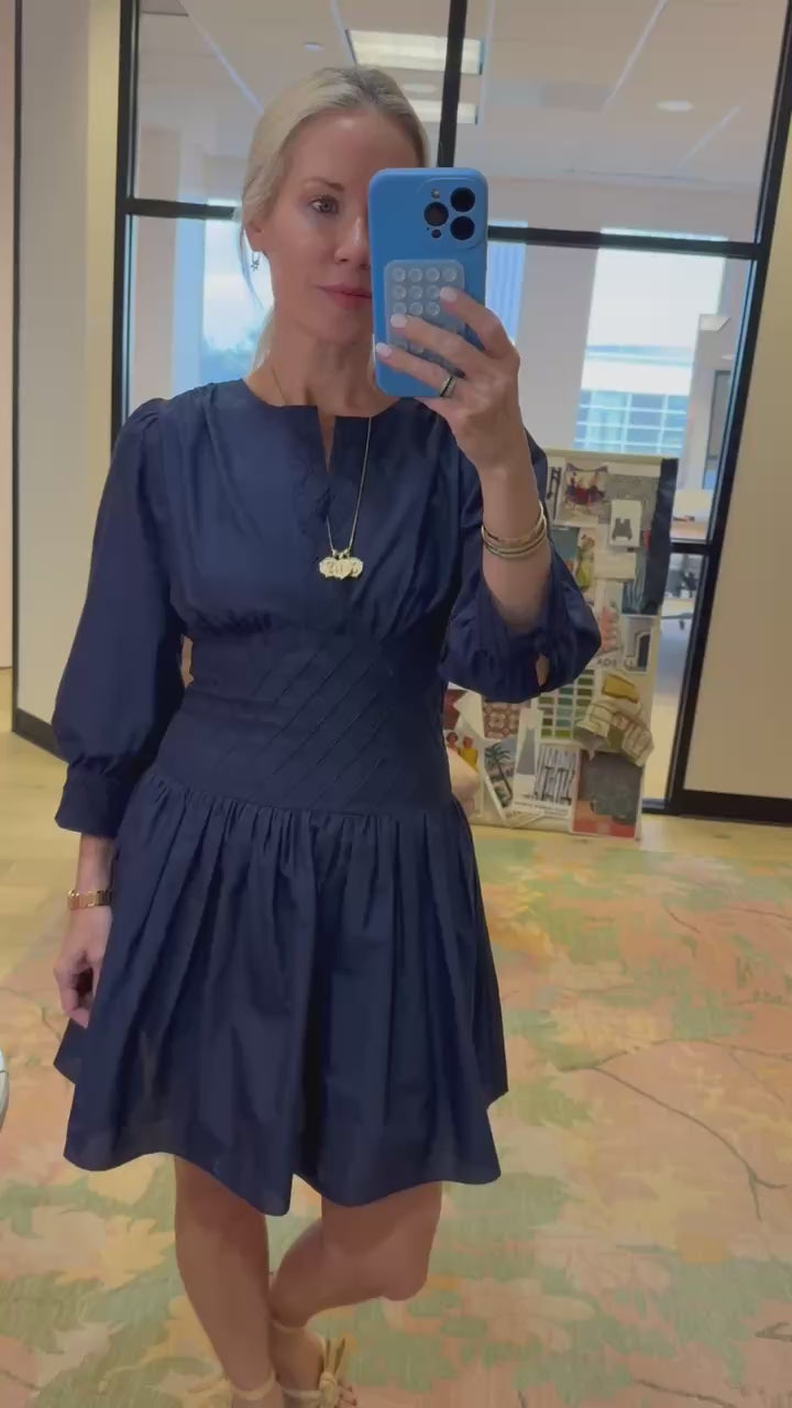 Hunter wearing a navy dress in her office