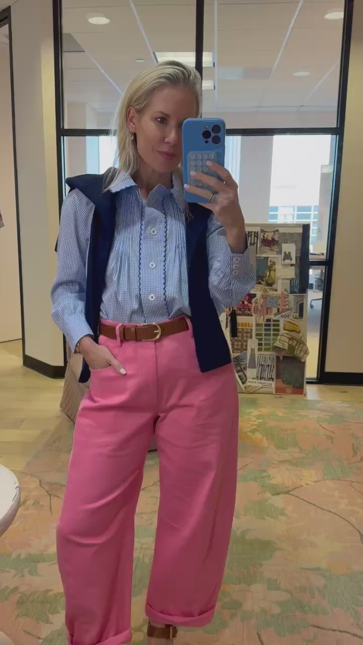 Hunter wearing pink pants, checked shirt top, navy sweater over the shoulders.